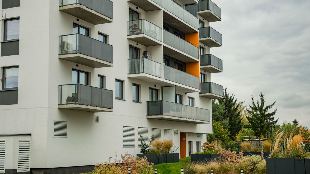 Apartment building with glass balconies representing renting versus buying decisions